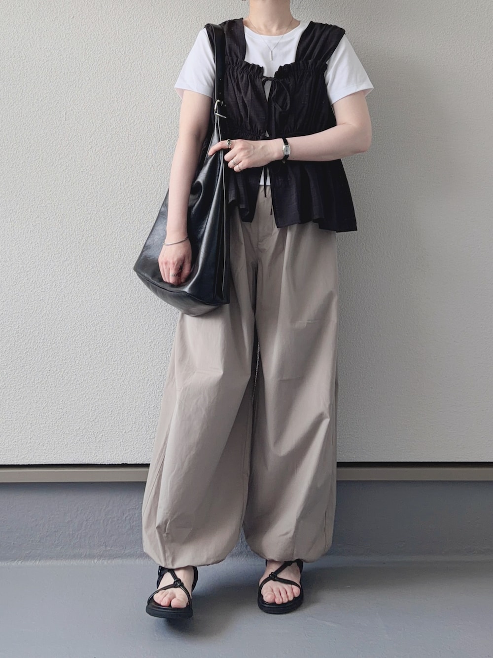 ブラック系のシャツ/ブラウス、ホワイト系のTシャツ/カットソー、ベージュ系のパンツを着用したレディースの夏コーディネートの2枚目の写真