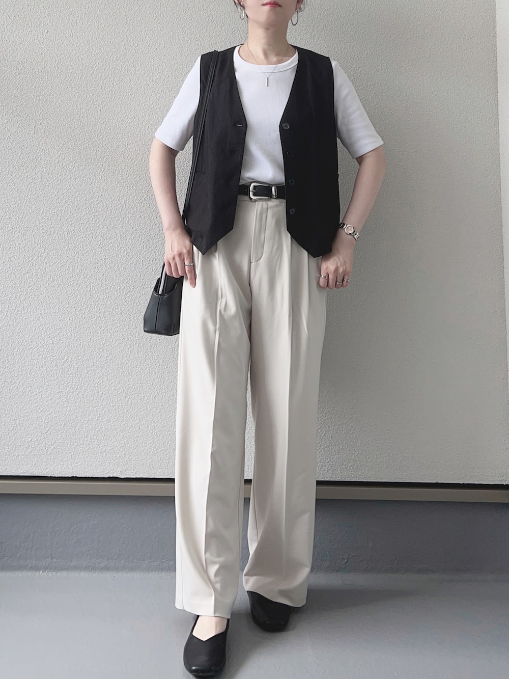ホワイト系のTシャツ/カットソー、ブラック系のベスト、ホワイト系のパンツを着用したレディースの夏コーディネートの2枚目の写真