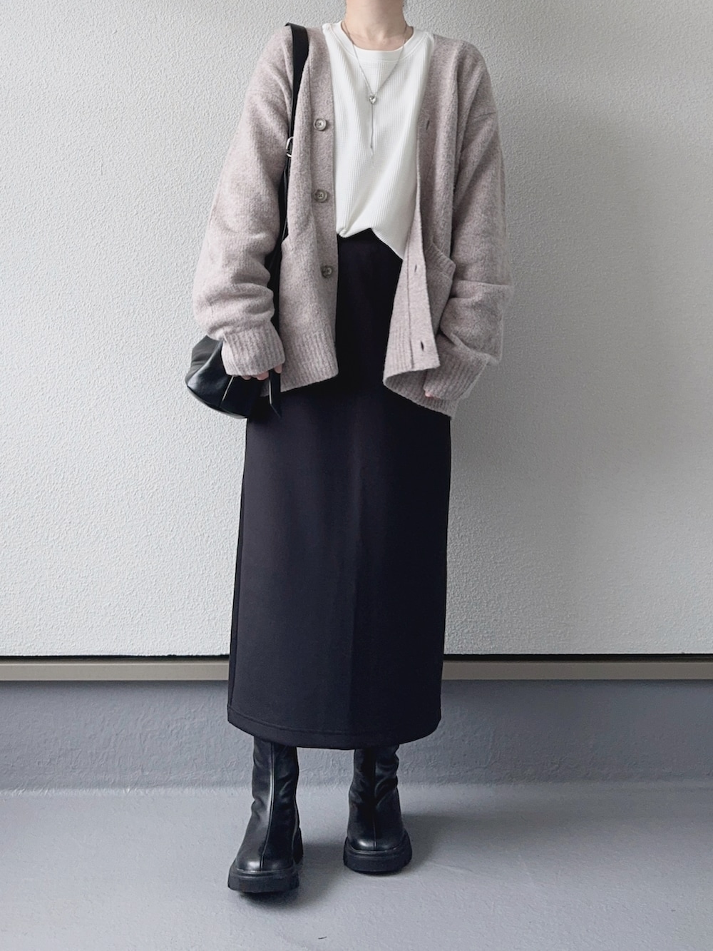 ベージュ系のカーディガン/ボレロ、ホワイト系のTシャツ/カットソー、ブラック系のスカートを着用したレディースの秋コーディネートの2枚目の写真