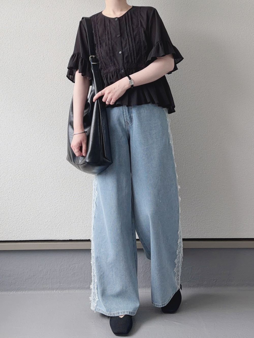 ブルー系のデニムパンツ、ブラック系のシャツ/ブラウス、ブラック系のショルダーバッグを着用したレディースの夏コーディネートの4枚目の写真