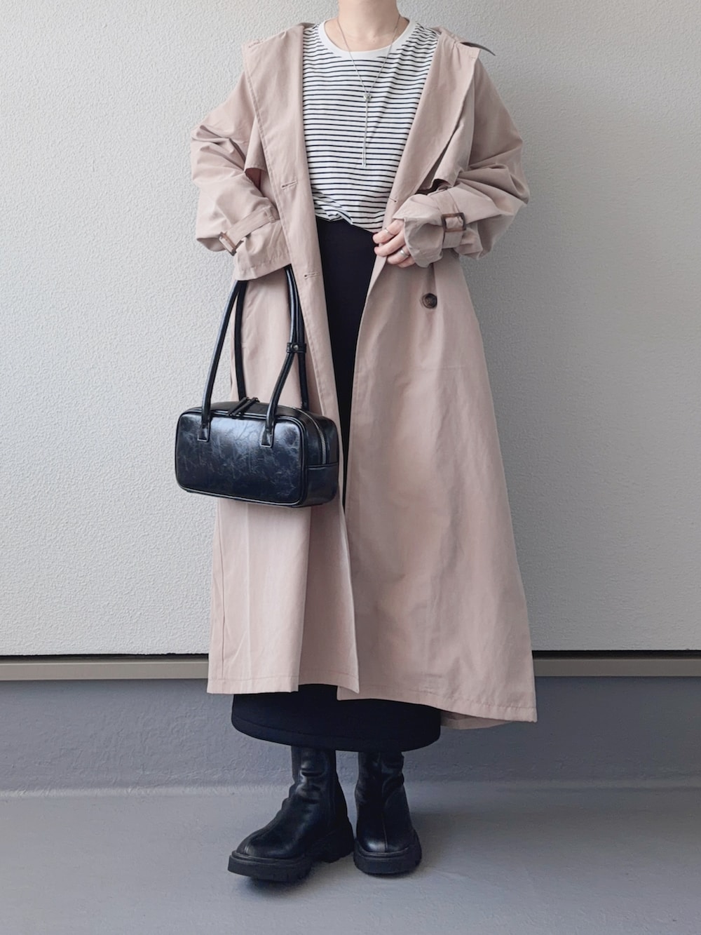 ベージュ系のトレンチコート、ブラック系のブーツ、ホワイト系のTシャツ/カットソーを着用したレディースの春コーディネートの4枚目の写真