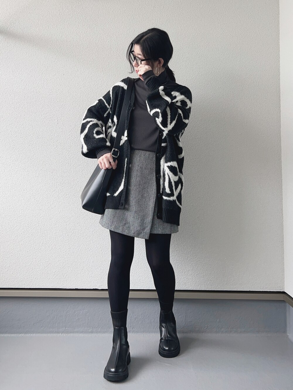 ブラック系のカーディガン/ボレロ、グレー系のTシャツ/カットソー、グレー系のスカートを着用したレディースの秋コーディネートの2枚目の写真