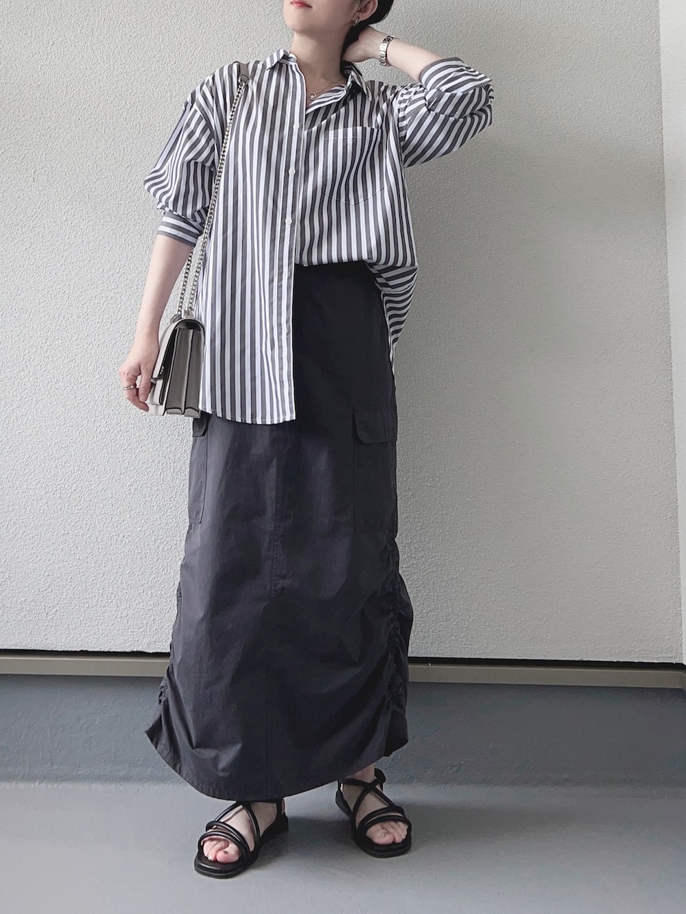 グレー系のシャツ/ブラウス、グレー系のスカート、ブラック系のサンダルを着用したレディースの秋コーディネートの2枚目の写真