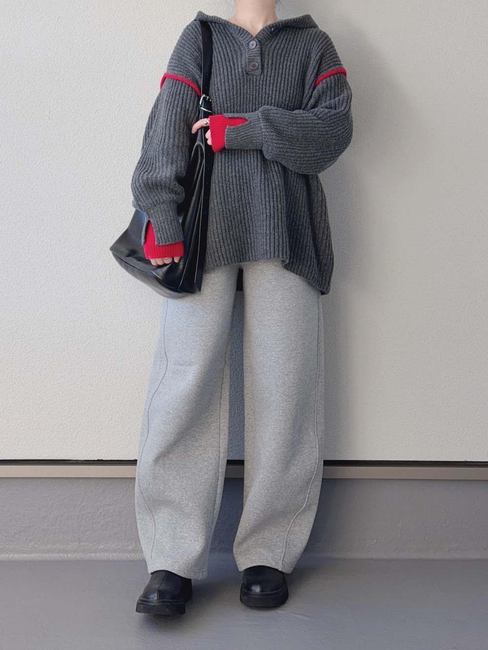グレー系のニット/セーター、ブラック系のブーツ、グレー系のスウェットパンツを着用したレディースの冬コーディネートの2枚目の写真