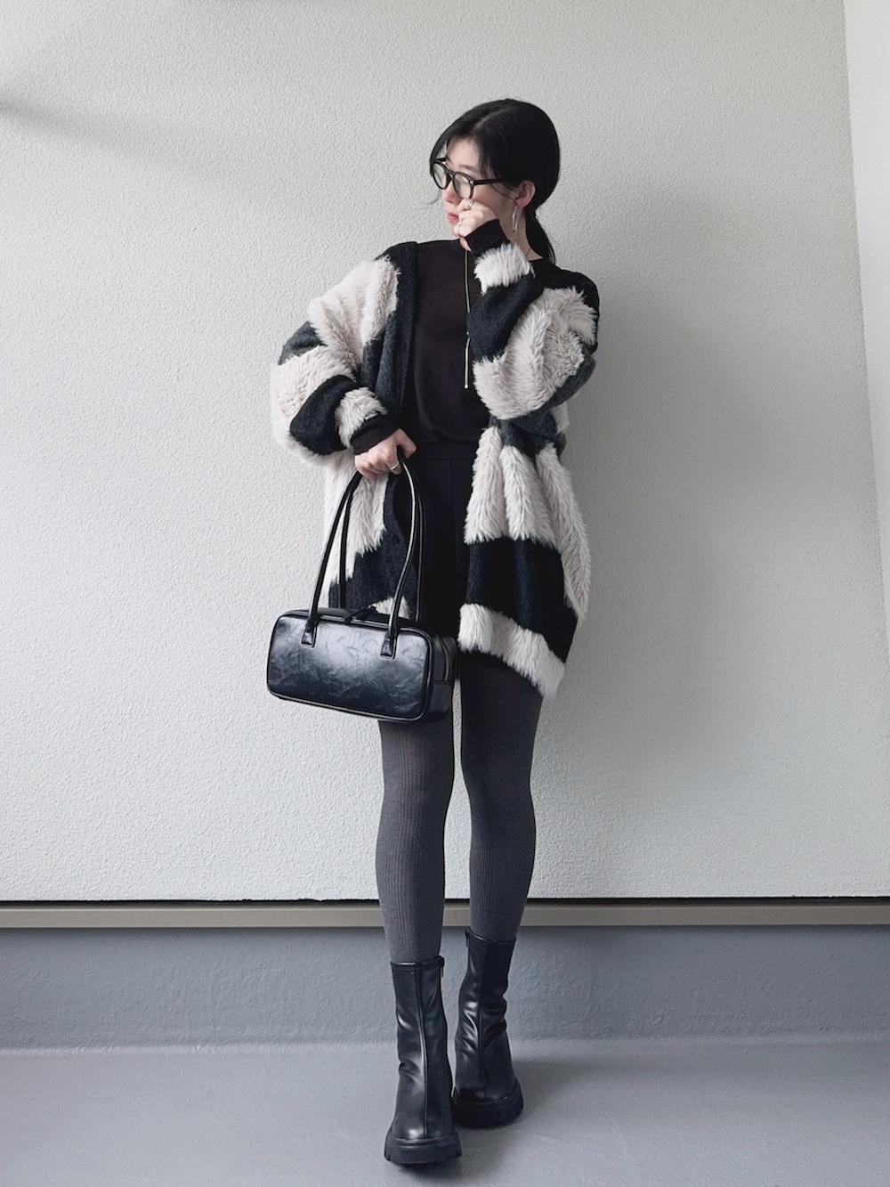 ブラック系のカーディガン/ボレロ、ブラック系のその他パンツ、ブラック系のブーツを着用したレディースの秋コーディネートの5枚目の写真