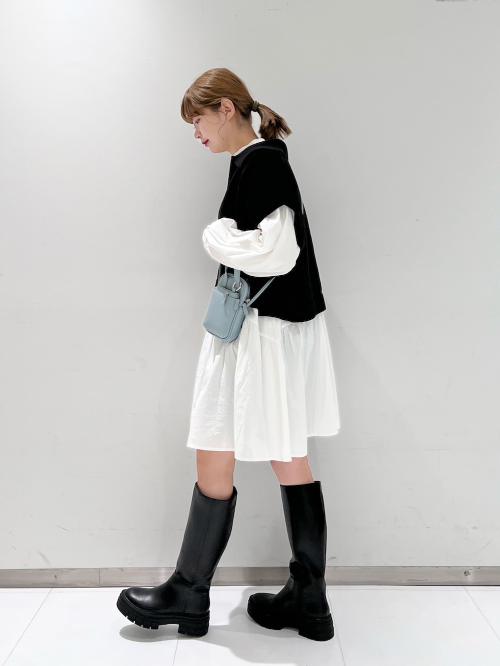 ホワイト系のシャツ/ブラウス、ブラック系のベスト、ブラック系のブーツを着用したレディースの春コーディネートの3枚目の写真