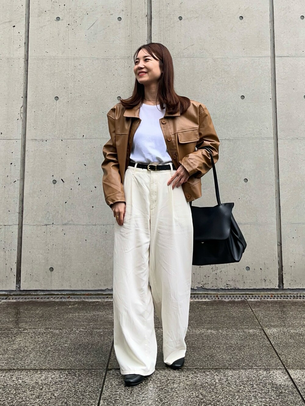 ホワイト系のパンツ、ブラック系のローファー、ブラウン系のブルゾンを着用したレディースの冬コーディネートの2枚目の写真