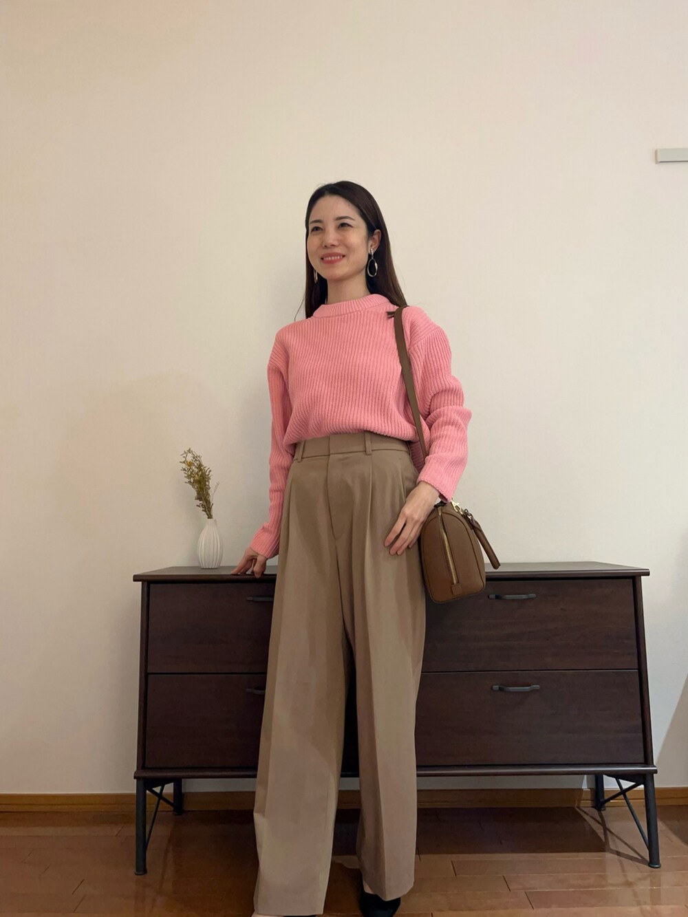 ピンク系のトップス、ホワイト系のパンツ、ブラウン系のショルダーバッグを着用したレディースの冬コーディネートの3枚目の写真