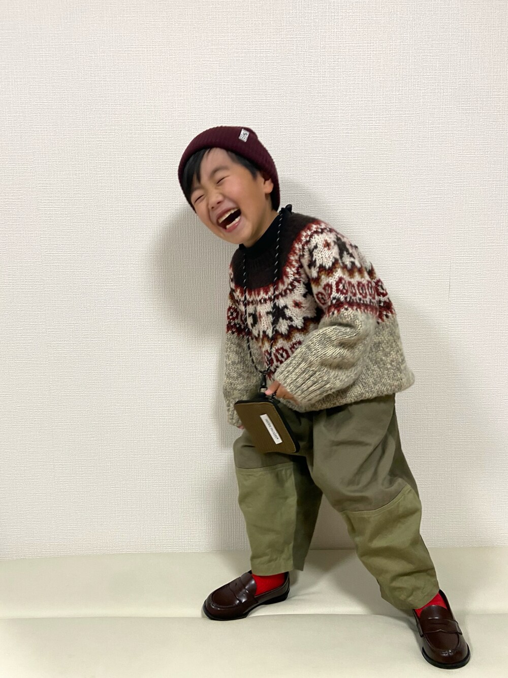 ベージュ系のニット/セーター、グリーン系のその他パンツ、ブラウン系のローファーを着用したキッズの冬コーディネートの3枚目の写真