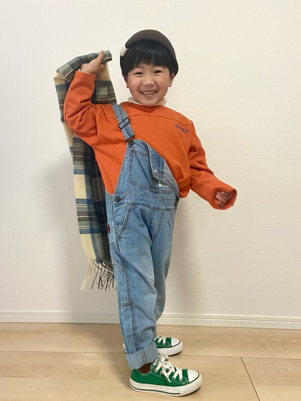 オレンジ系のTシャツ/カットソー、ブルー系のサロペット/オーバーオール、ホワイト系のニット/セーターを着用したキッズの冬コーディネートの3枚目の写真