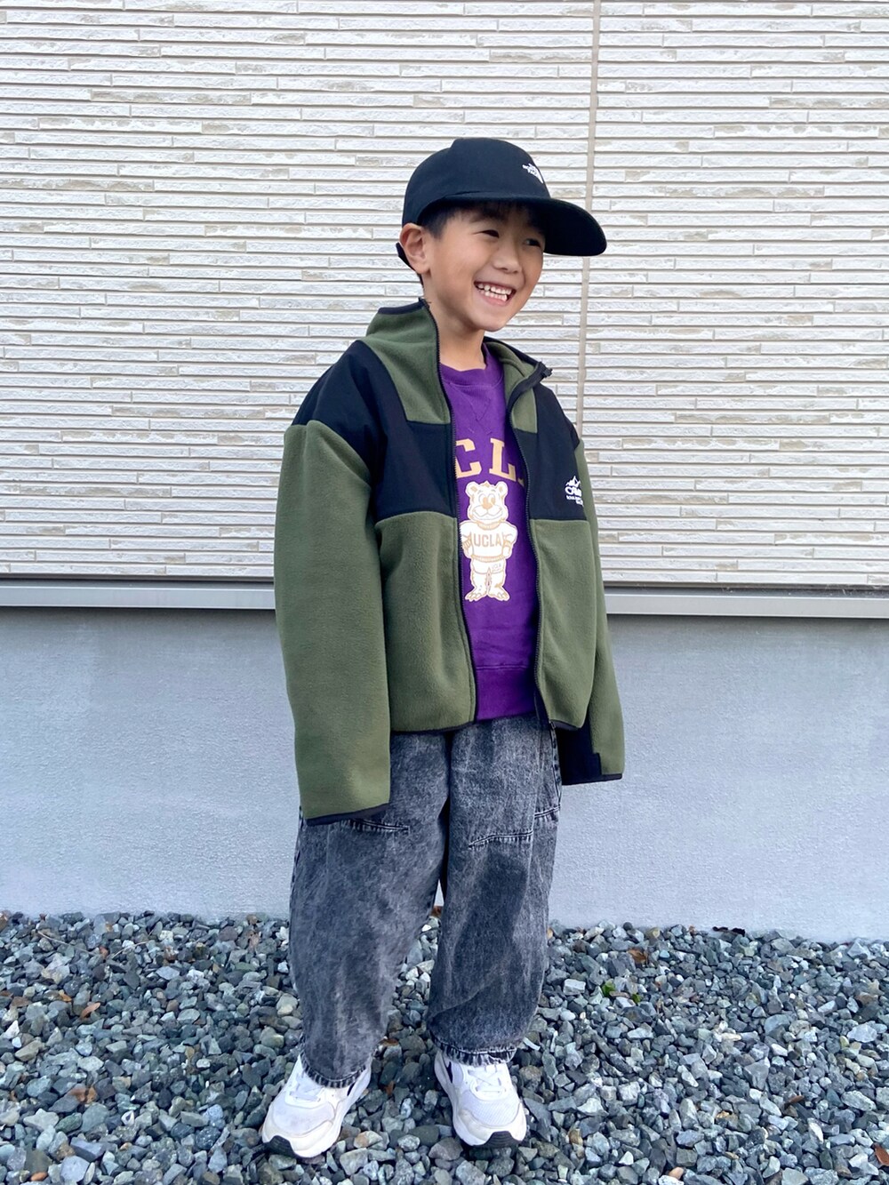 グリーン系のブルゾン、ブラック系のデニムパンツ、パープル系のスウェットを着用したキッズの冬コーディネートの2枚目の写真