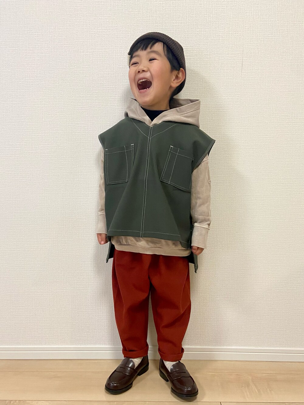 ベージュ系のパーカー、グリーン系のベスト、ブラック系のTシャツ/カットソーを着用したキッズの冬コーディネートの2枚目の写真
