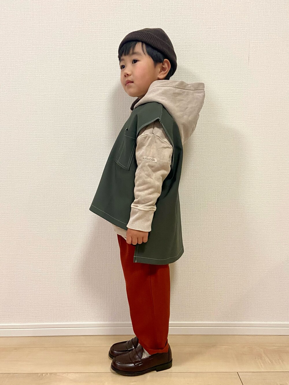 ベージュ系のパーカー、グリーン系のベスト、ブラック系のTシャツ/カットソーを着用したキッズの冬コーディネートの3枚目の写真