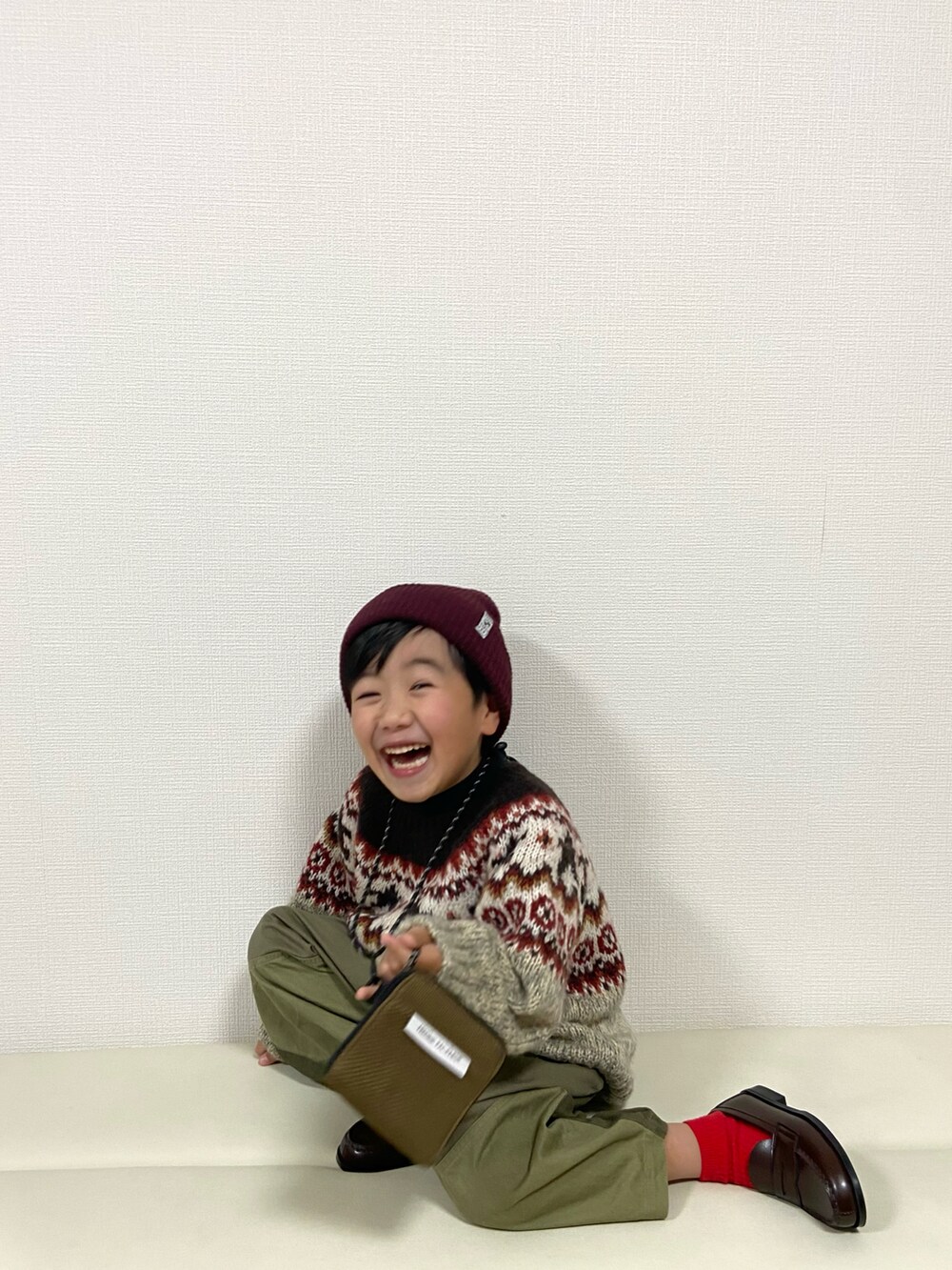 ベージュ系のニット/セーター、グリーン系のその他パンツ、ブラウン系のローファーを着用したキッズの冬コーディネートの4枚目の写真