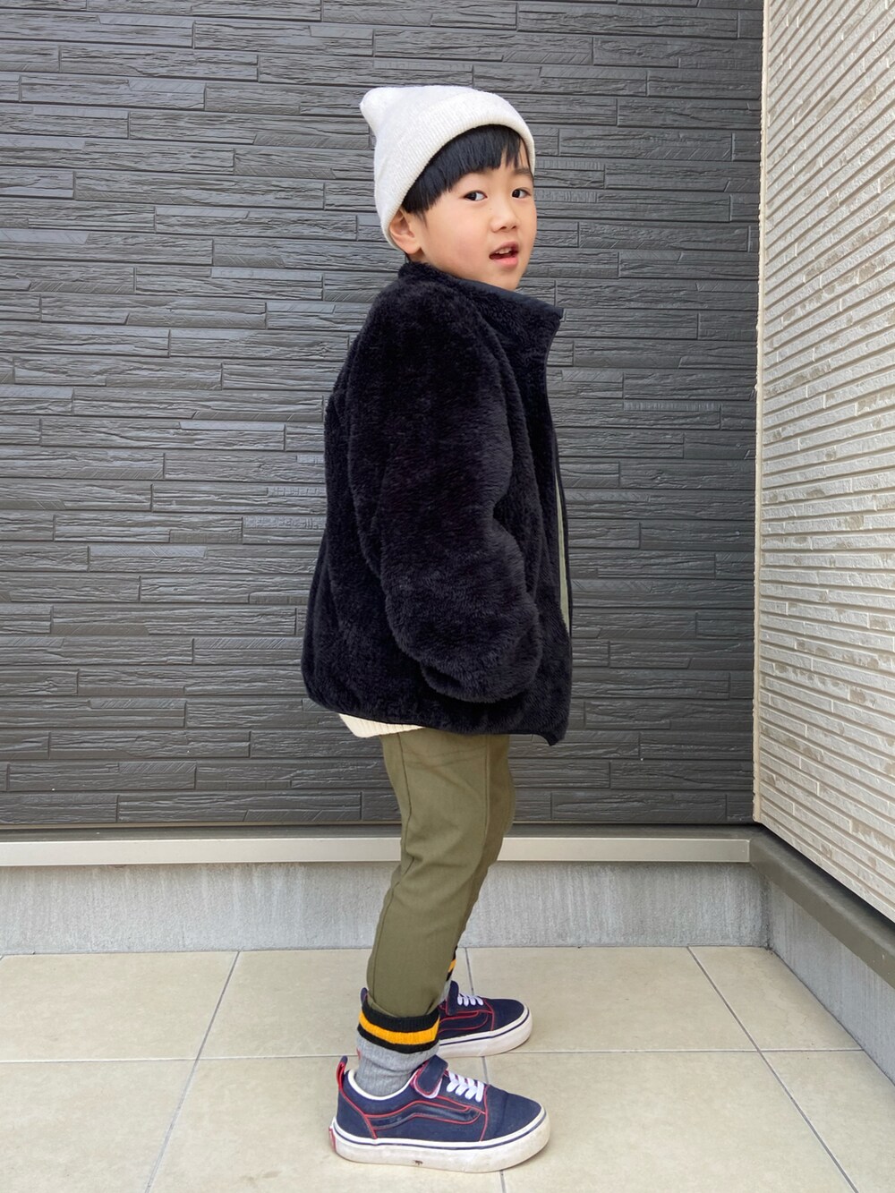 グレー系のニット/セーター、グリーン系のブルゾン、グリーン系のパンツを着用したキッズの冬コーディネートの2枚目の写真
