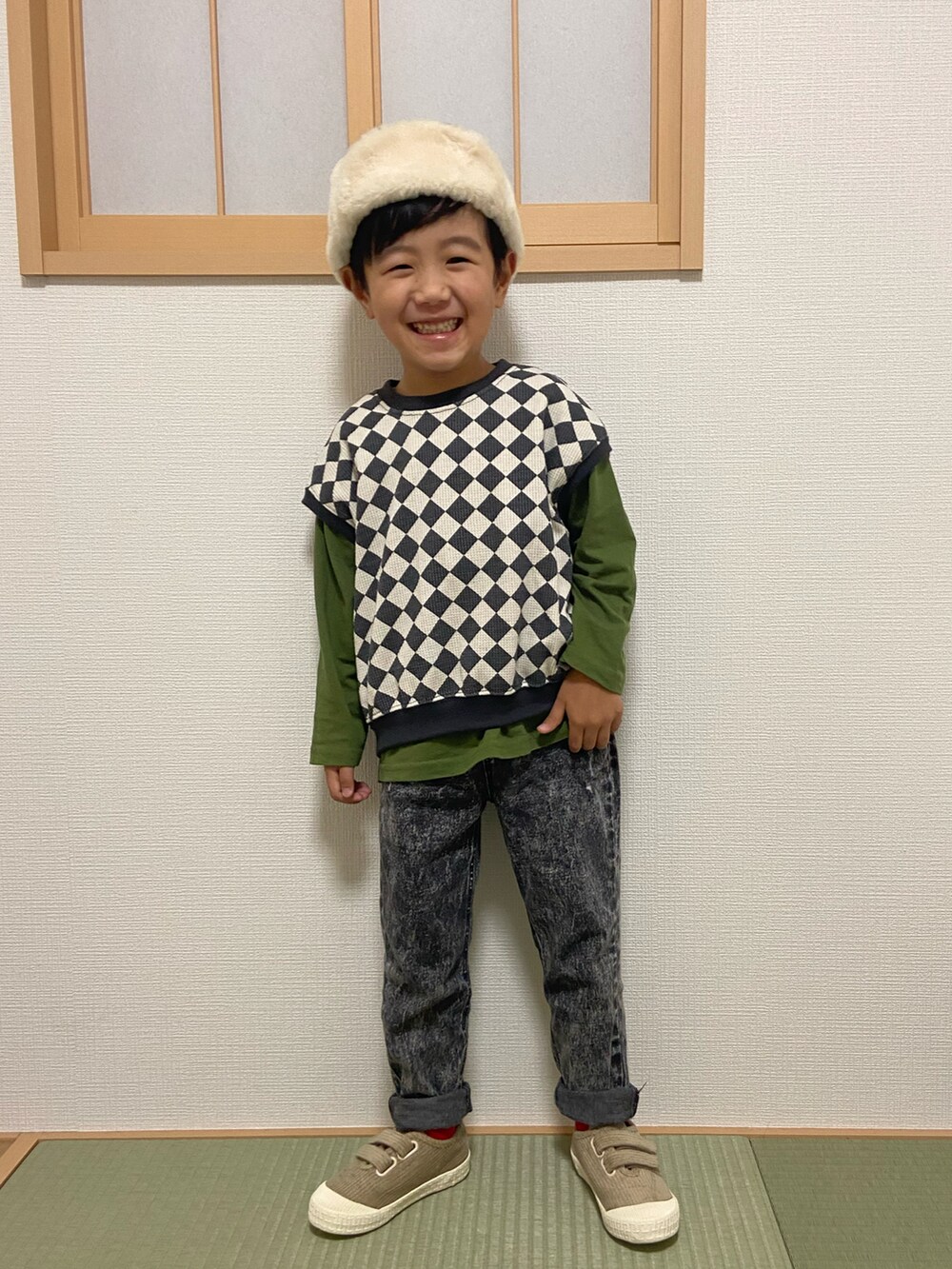 ブラック系のベスト、グリーン系のTシャツ/カットソー、ブラック系のデニムパンツを着用したキッズの秋コーディネートの2枚目の写真