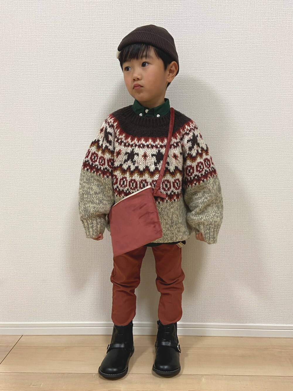 ベージュ系のニット/セーター、レッド系のその他パンツ、グリーン系のシャツ/ブラウスを着用したキッズの冬コーディネートの2枚目の写真