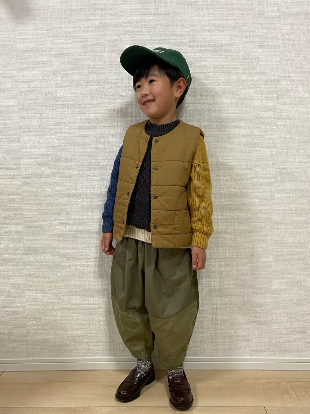 グレー系のニット/セーター、グリーン系のその他パンツ、ブラウン系のベストを着用したキッズの冬コーディネートの3枚目の写真