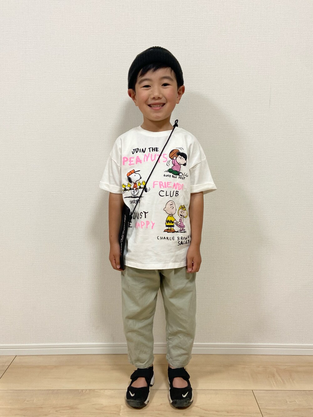 ホワイト系のTシャツ/カットソー、グリーン系のパンツ、ブラック系のサンダルを着用したキッズの春コーディネートの2枚目の写真