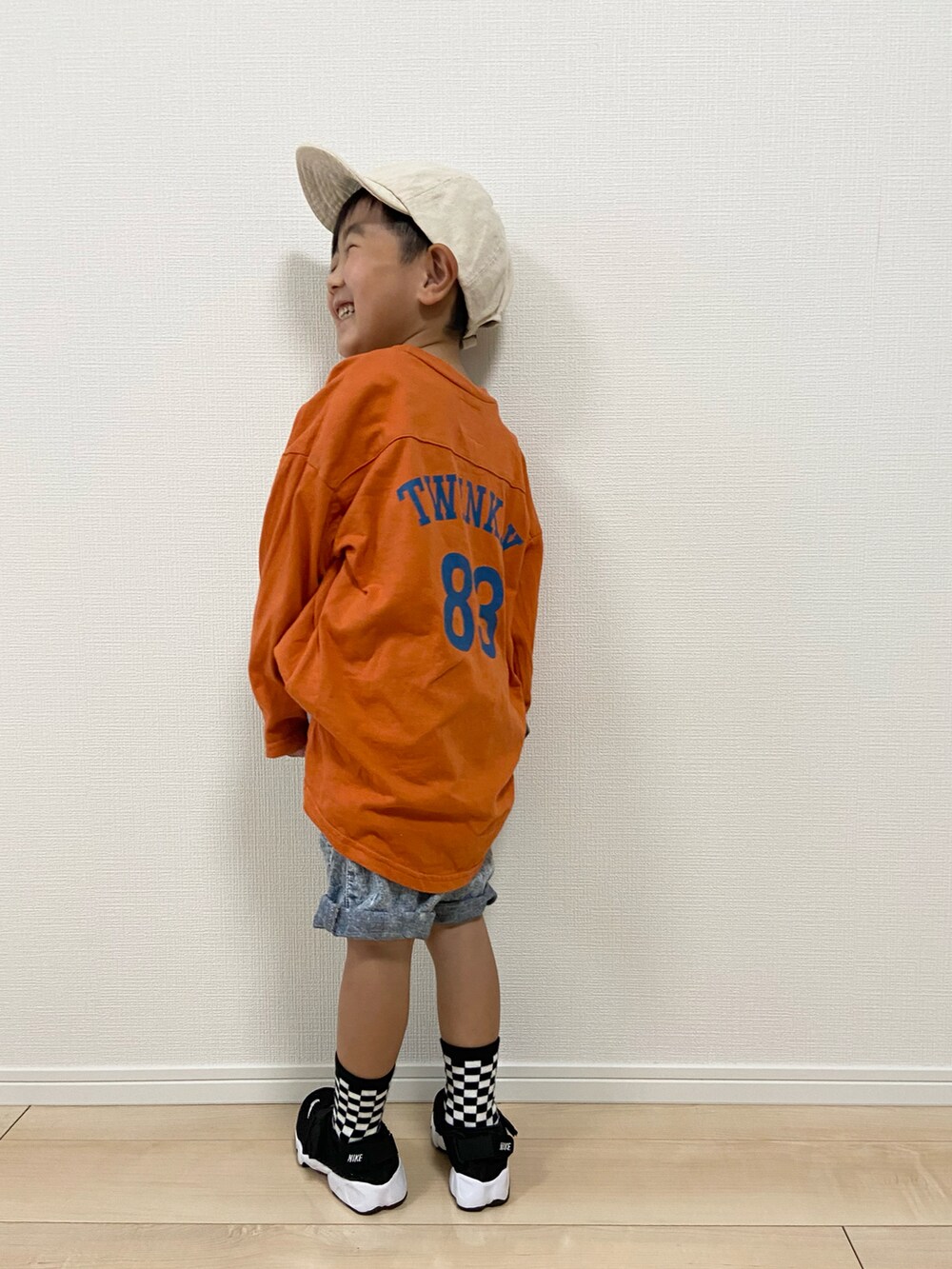 オレンジ系のTシャツ/カットソー、その他のデニムパンツ、ブラック系のサンダルを着用したキッズの春コーディネートの2枚目の写真