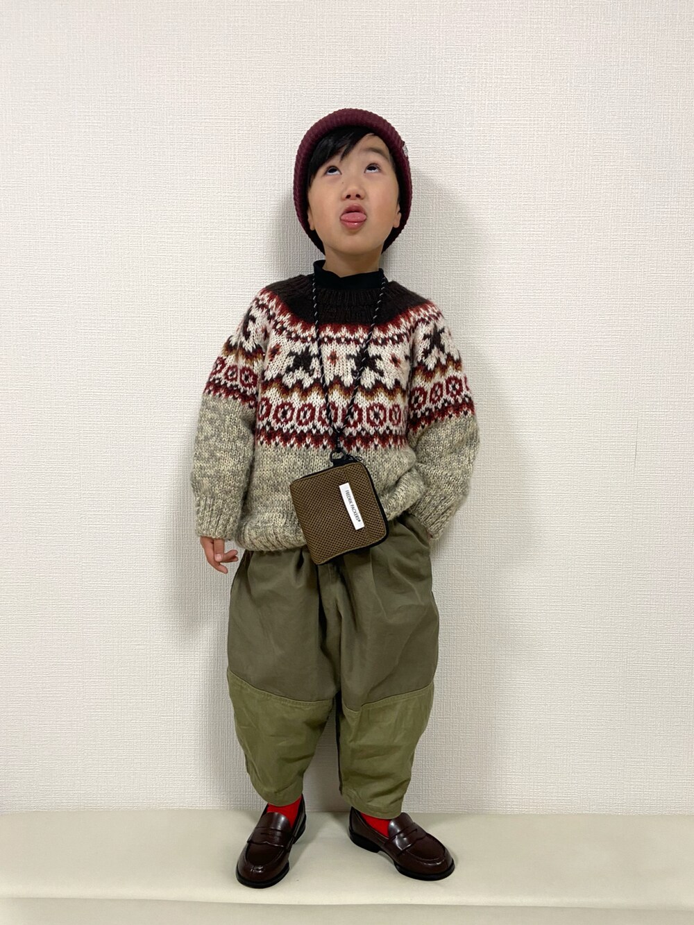 ベージュ系のニット/セーター、グリーン系のその他パンツ、ブラウン系のローファーを着用したキッズの冬コーディネートの2枚目の写真