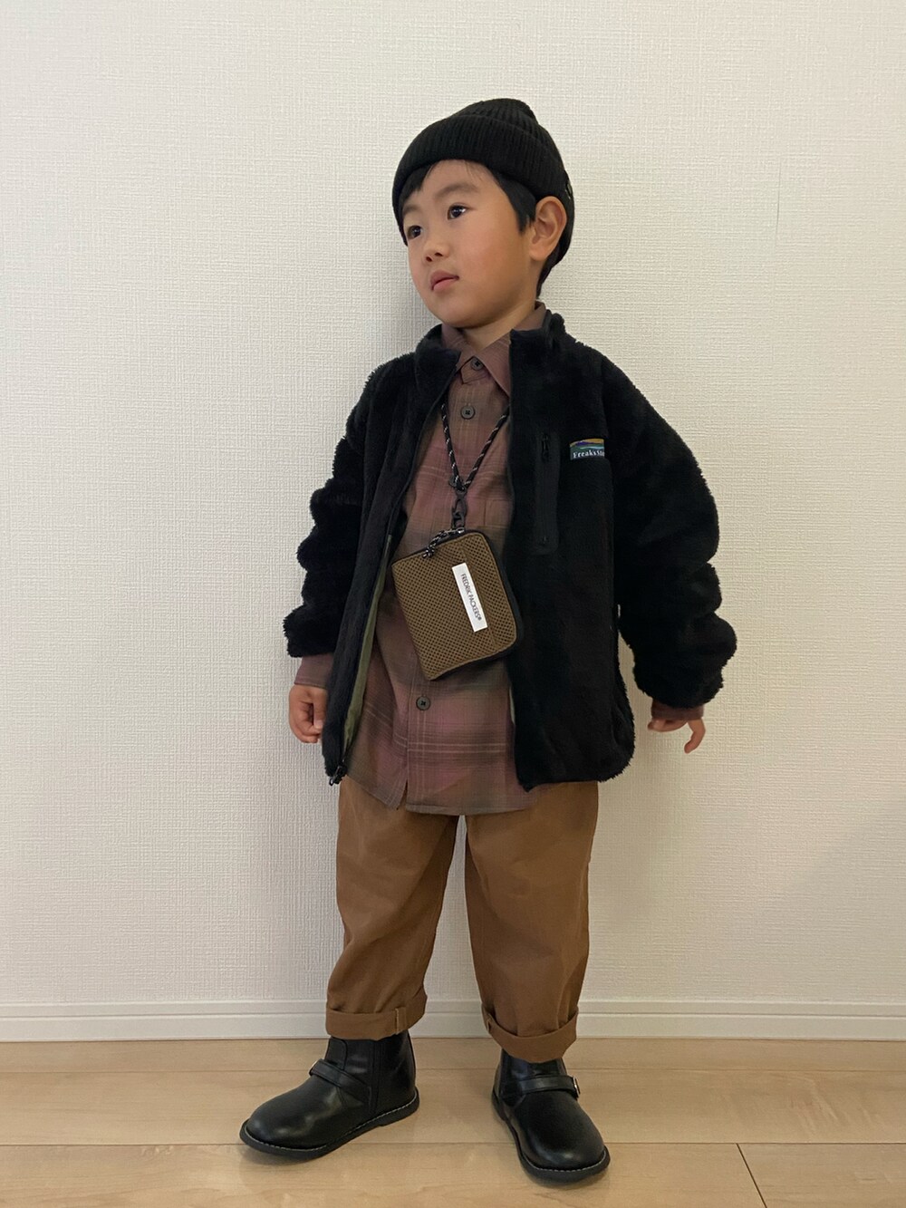 グリーン系のブルゾン、パープル系のシャツ/ブラウス、ブラウン系のチノパンツを着用したキッズの冬コーディネートの2枚目の写真