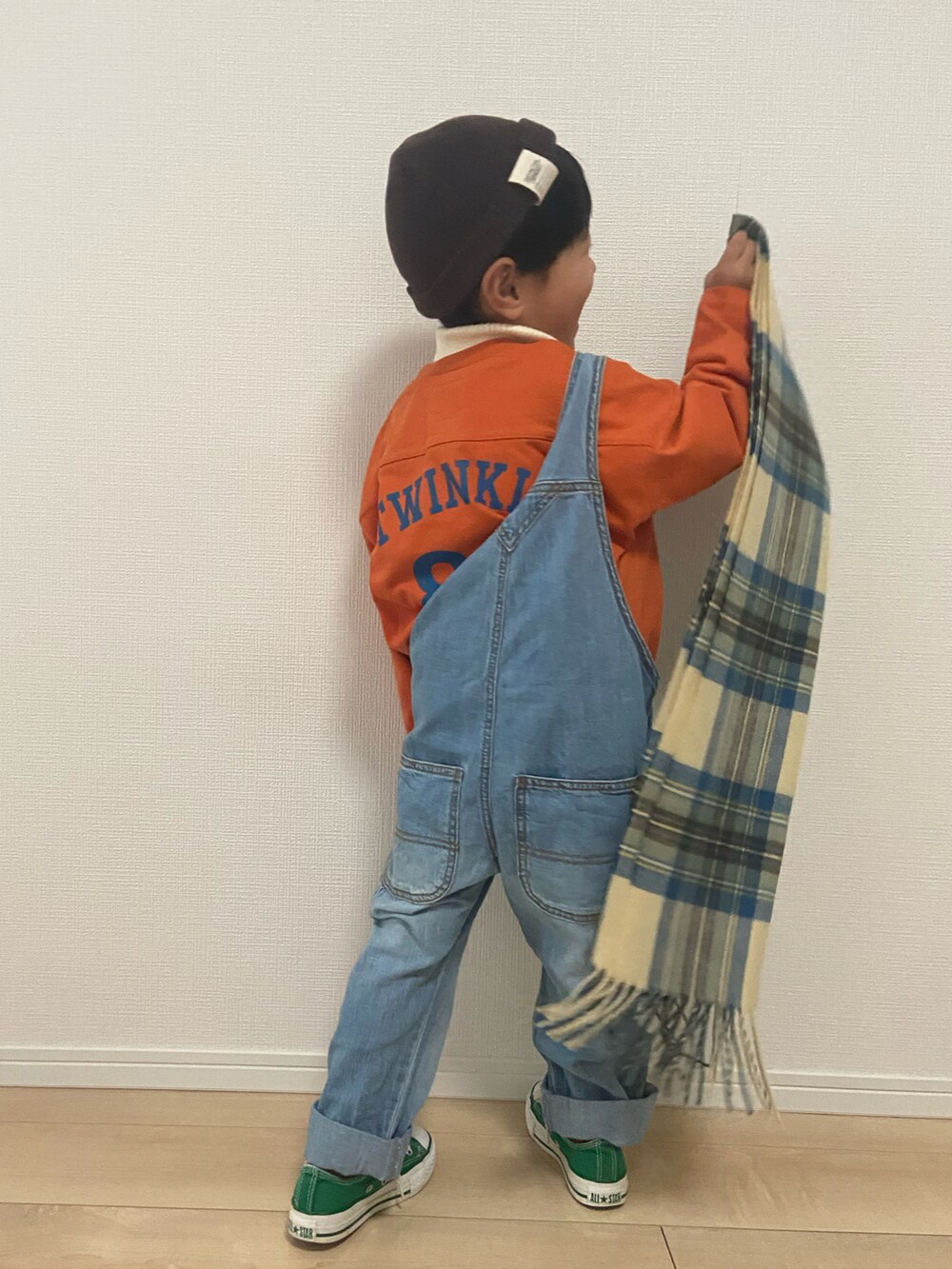 オレンジ系のTシャツ/カットソー、ブルー系のサロペット/オーバーオール、ホワイト系のニット/セーターを着用したキッズの冬コーディネートの5枚目の写真