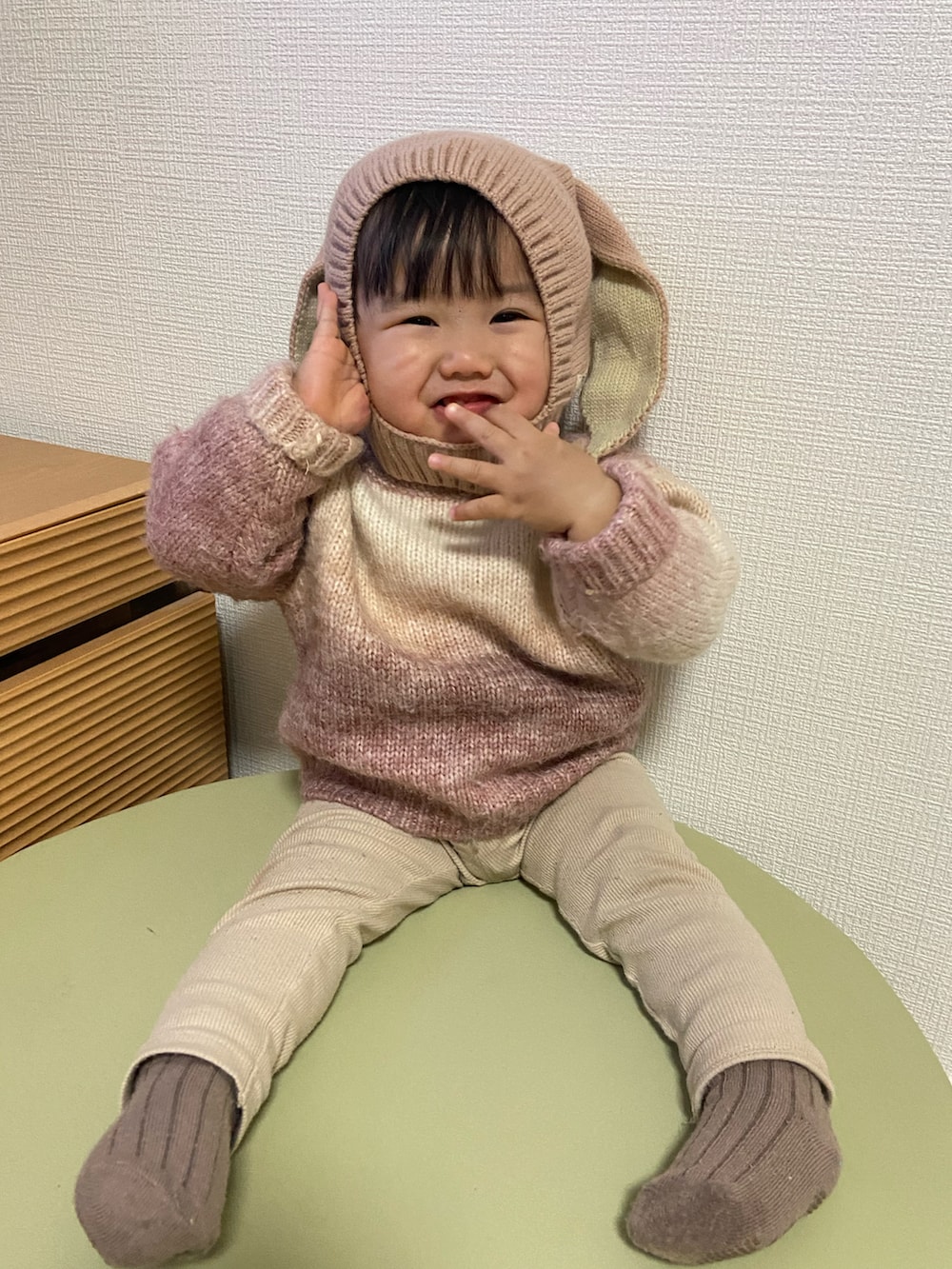 ピンク系のニット/セーター、ベージュ系のレギンス/スパッツ、ピンク系のニットキャップ/ビーニーを着用したキッズの冬コーディネートの2枚目の写真