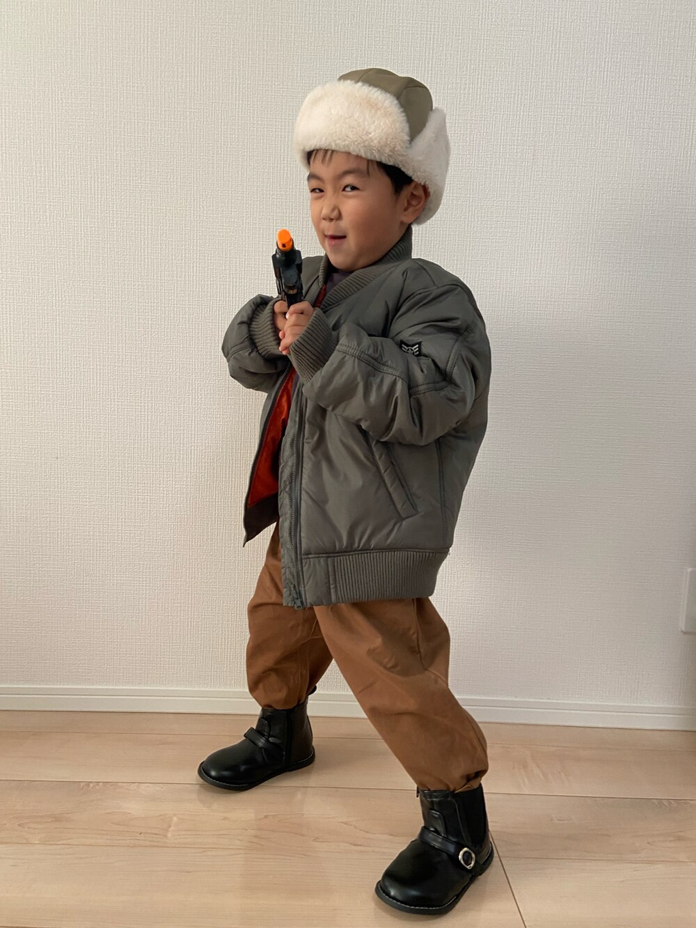 ブラック系のスウェット、ブラウン系のチノパンツ、グリーン系のMA-1を着用したキッズの秋コーディネートの4枚目の写真