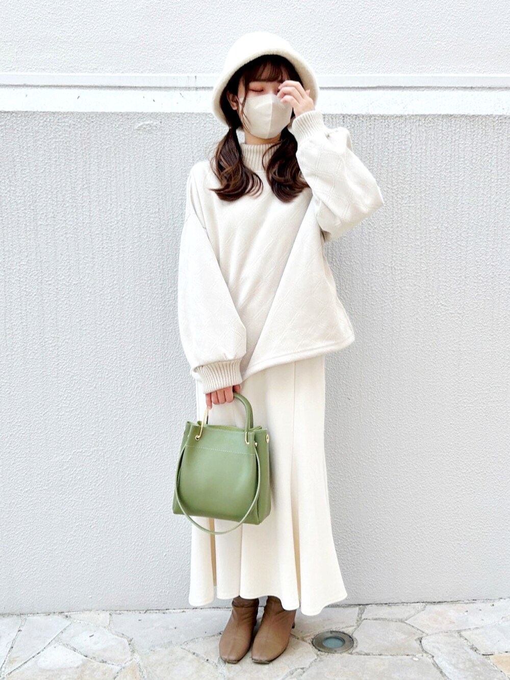 ブラウン系のブーツ、グリーン系のハンドバッグ、ホワイト系のスカートを着用したレディースの秋コーディネートの2枚目の写真