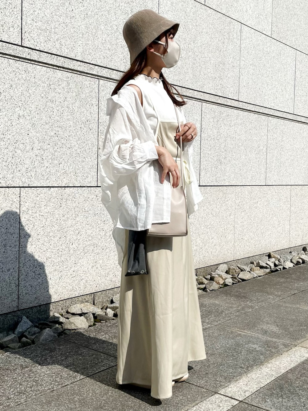 ホワイト系のショルダーバッグ、ベージュ系のワンピース、ホワイト系のシャツ/ブラウスを着用したレディースの夏コーディネートの2枚目の写真