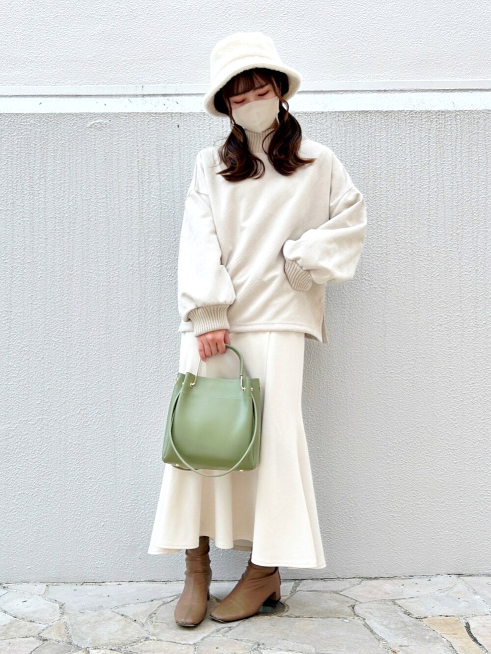 ブラウン系のブーツ、グリーン系のハンドバッグ、ホワイト系のスカートを着用したレディースの秋コーディネートの3枚目の写真