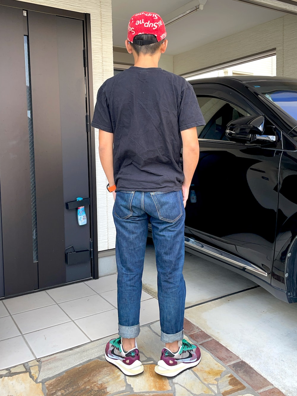 ブラック系のTシャツ/カットソー、ブルー系のデニムパンツ、その他のスニーカーを着用したメンズの秋コーディネートの2枚目の写真