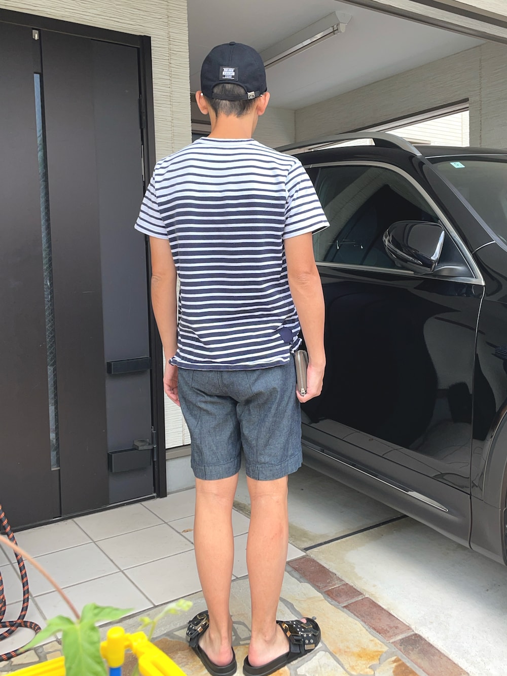 ブルー系のTシャツ/カットソー、グレー系のパンツ、ブラック系のサンダルを着用したメンズの夏コーディネートの2枚目の写真