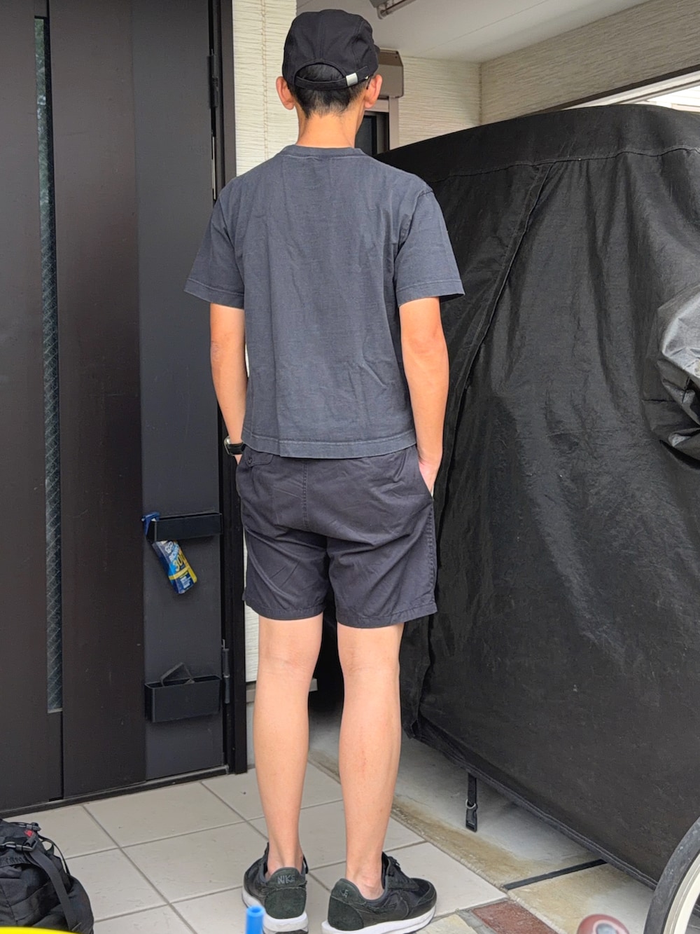 ブラック系のTシャツ/カットソー、ブラック系のパンツ、ブラック系のスニーカーを着用したメンズの夏コーディネートの2枚目の写真