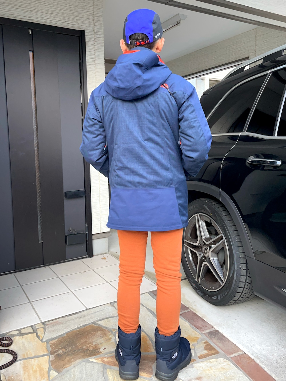 ブルー系のブーツ、ブラウン系のスウェットパンツ、ブルー系のナイロンジャケットを着用したメンズの冬コーディネートの2枚目の写真