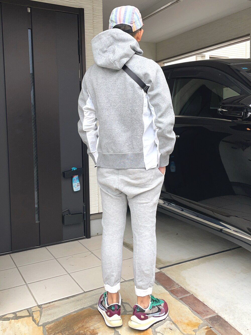 ブラック系のボディバッグ/ウエストポーチ、グレー系のスウェットパンツ、その他のスニーカーを着用したメンズの秋コーディネートの2枚目の写真
