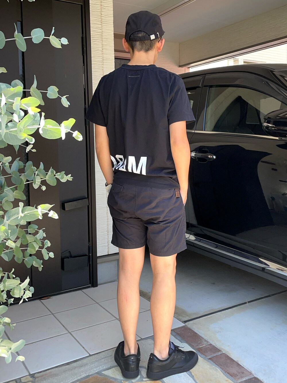 ブラック系のTシャツ/カットソー、ブラック系のパンツ、ブラック系のスニーカーを着用したメンズの夏コーディネートの2枚目の写真