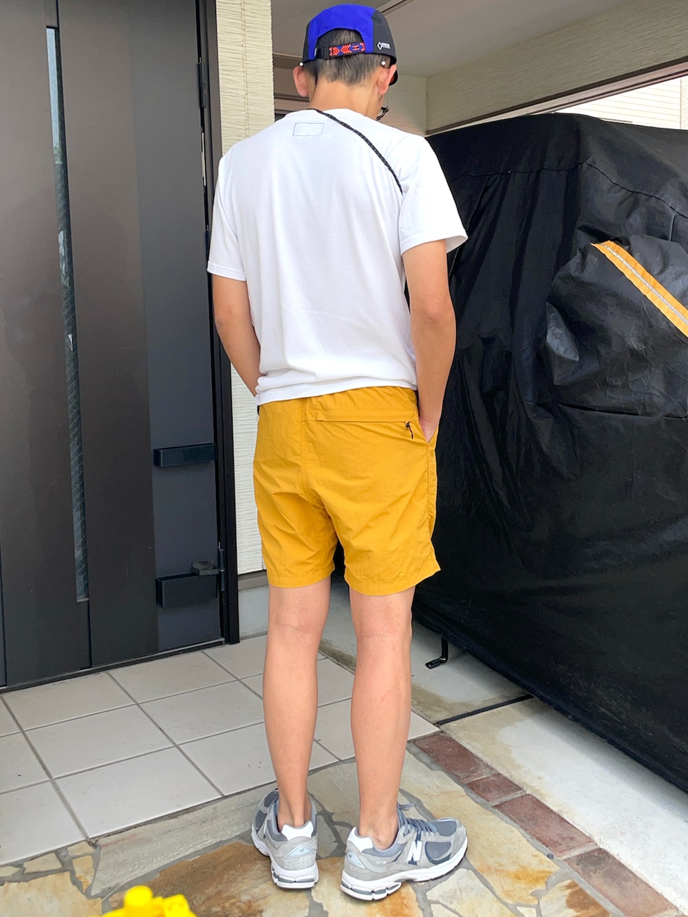 イエロー系のパンツ、グレー系のスニーカー、ホワイト系のTシャツ/カットソーを着用したメンズの夏コーディネートの2枚目の写真