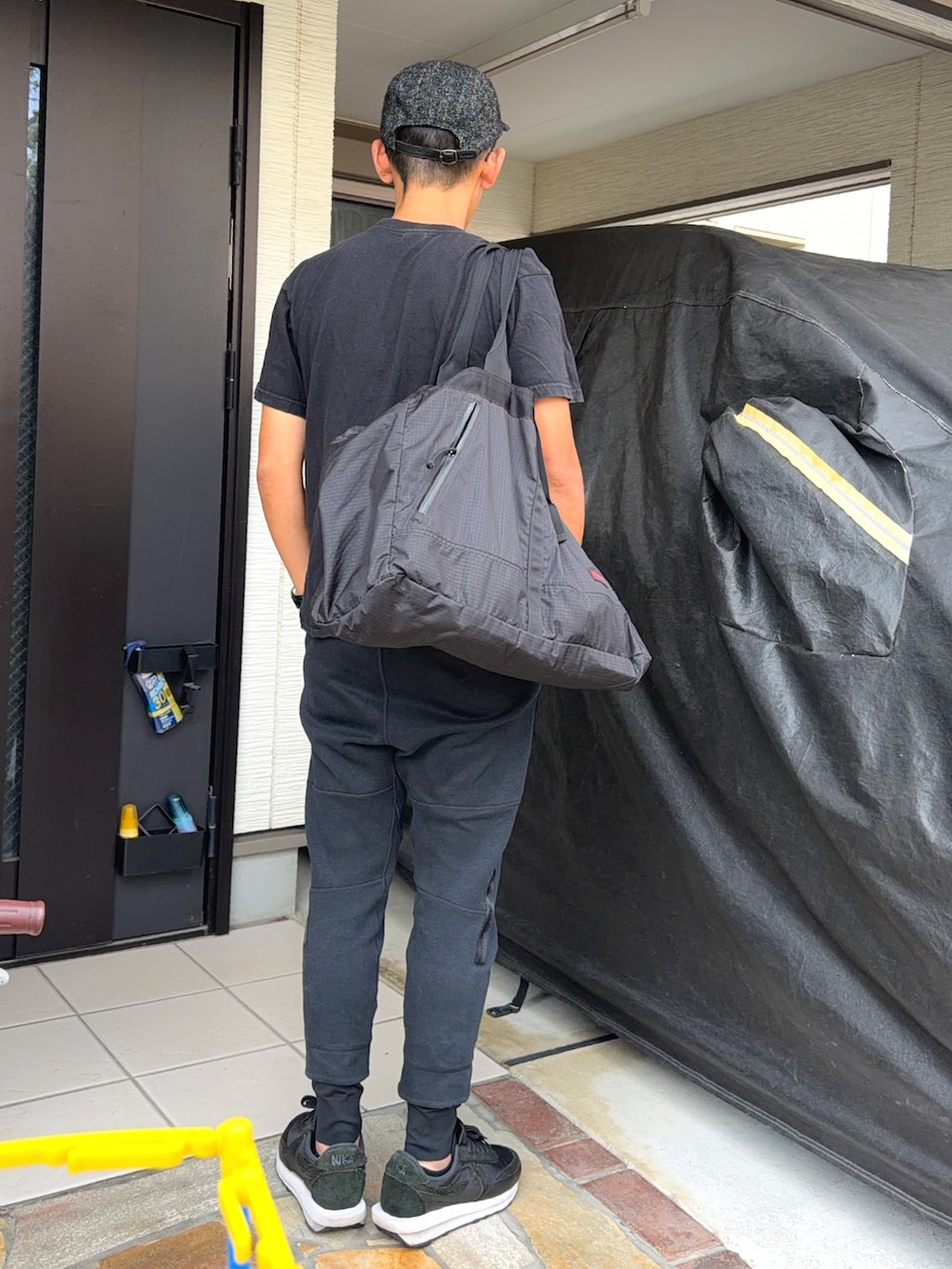 ブラック系のTシャツ/カットソー、ブラック系のパンツ、ブラック系のスニーカーを着用したメンズの秋コーディネートの2枚目の写真