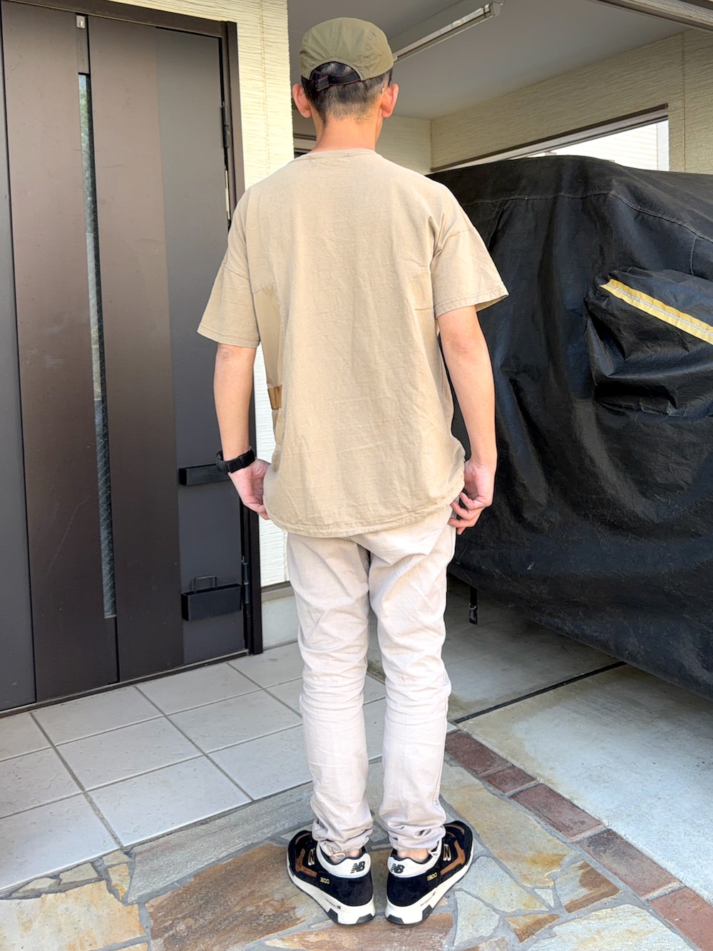 ベージュ系のTシャツ/カットソー、ベージュ系のカーゴパンツ、ブラック系のスニーカーを着用したメンズの春コーディネートの2枚目の写真