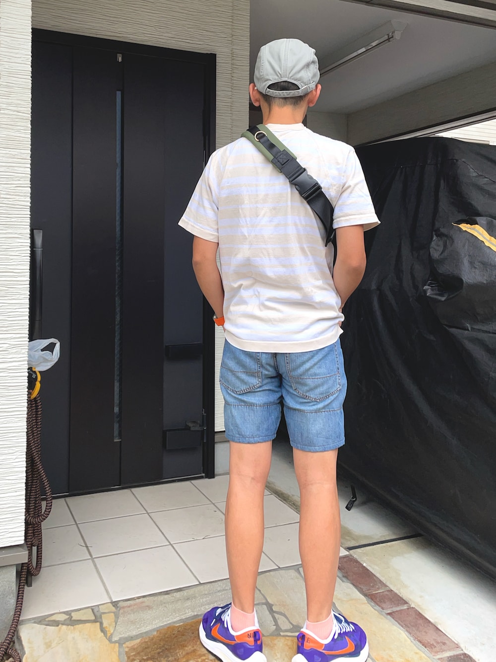 ピンク系のTシャツ/カットソー、ブルー系のデニムパンツ、パープル系のスニーカーを着用したメンズの秋コーディネートの2枚目の写真