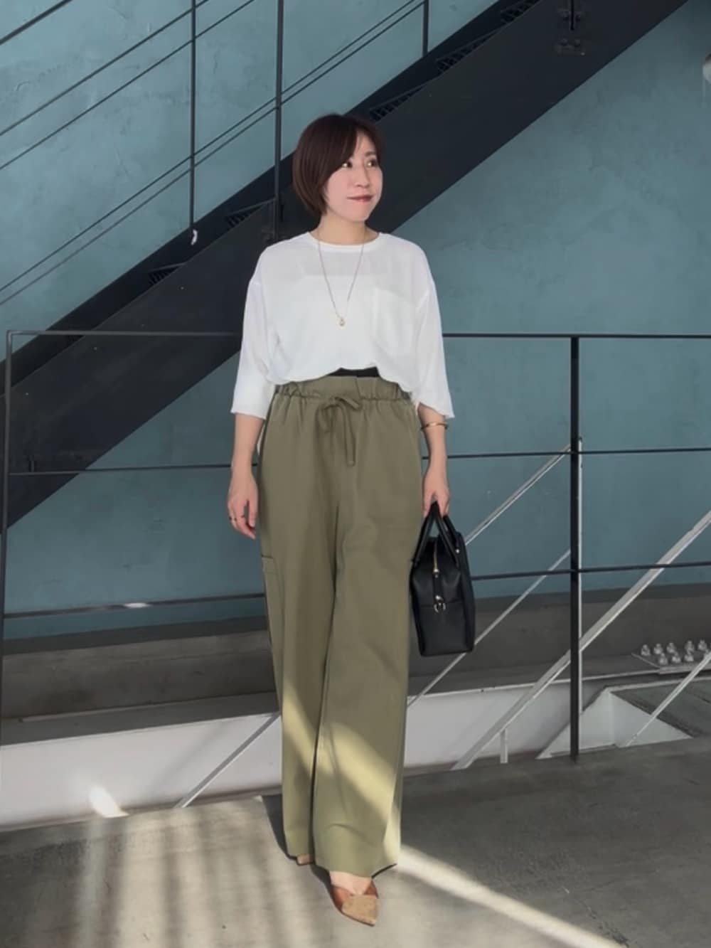 ホワイト系のシャツ/ブラウス、グリーン系のカーゴパンツ、ブラウン系のパンプスを着用したレディースの春コーディネートの2枚目の写真