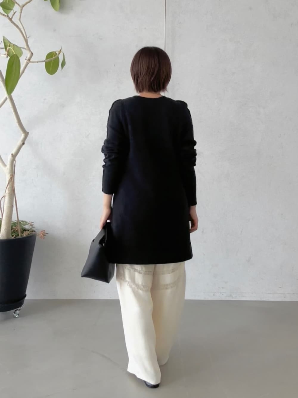 ホワイト系のその他パンツ、ブラック系のハンドバッグ、ブラック系のその他シューズを着用したレディースの冬コーディネートの4枚目の写真