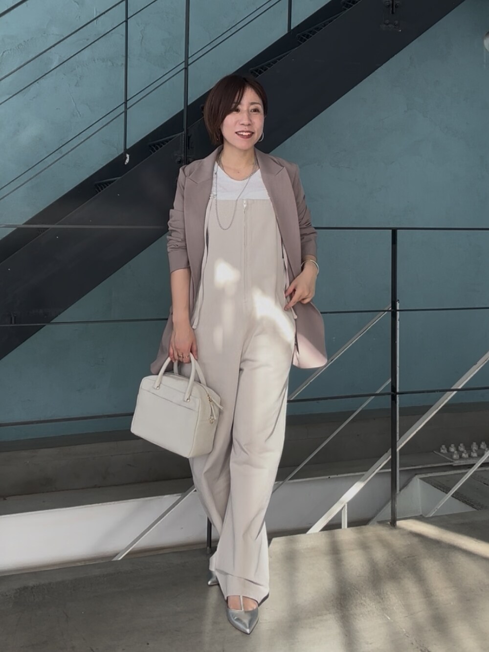 シルバー系のその他シューズ、ホワイト系のボストンバッグ、ベージュ系のサロペット/オーバーオールを着用したレディースの冬コーディネートの4枚目の写真