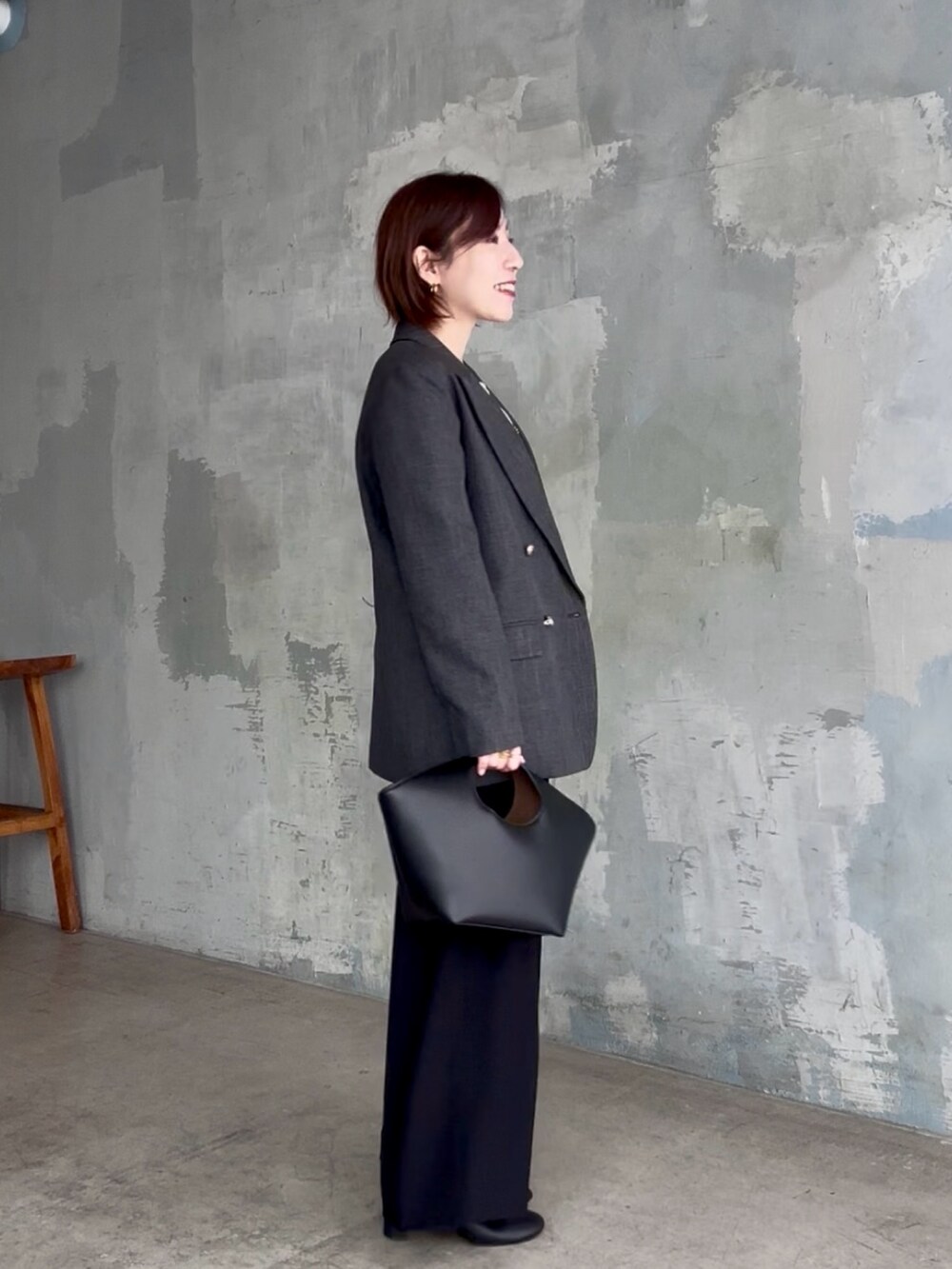 ブラック系のスラックス、ホワイト系のTシャツ/カットソー、グレー系のテーラードジャケットを着用したレディースの秋コーディネートの4枚目の写真