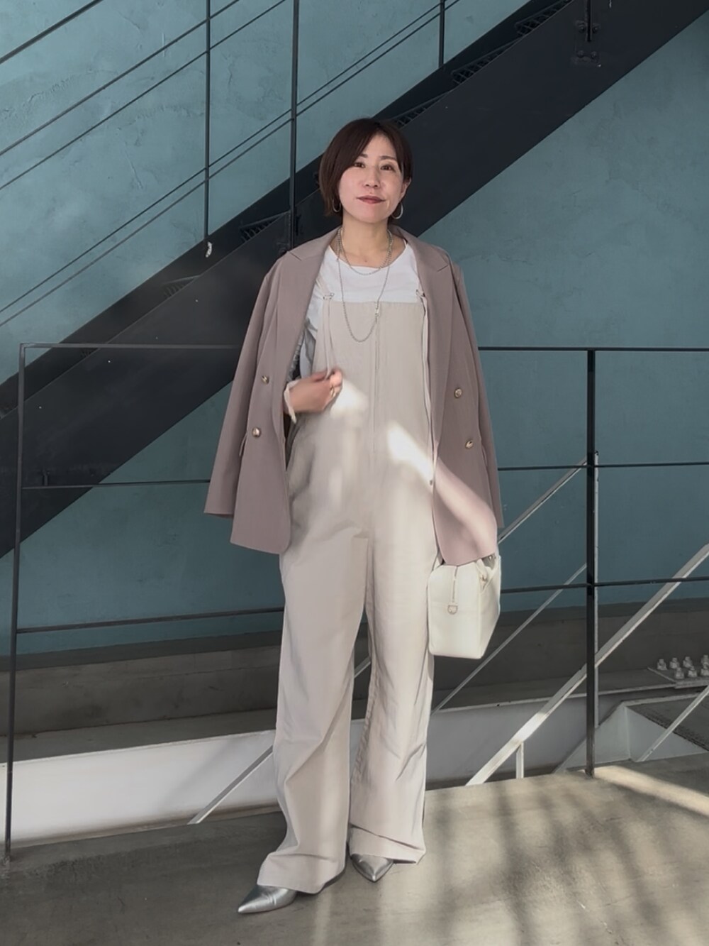 シルバー系のその他シューズ、ホワイト系のボストンバッグ、ベージュ系のサロペット/オーバーオールを着用したレディースの冬コーディネートの2枚目の写真