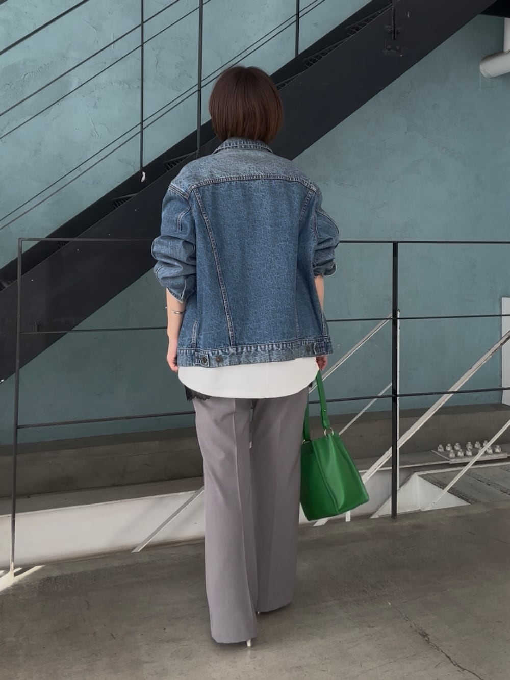 ブルー系のデニムジャケット、ホワイト系のスウェット、ブラック系のキャミソールを着用したレディースの冬コーディネートの5枚目の写真