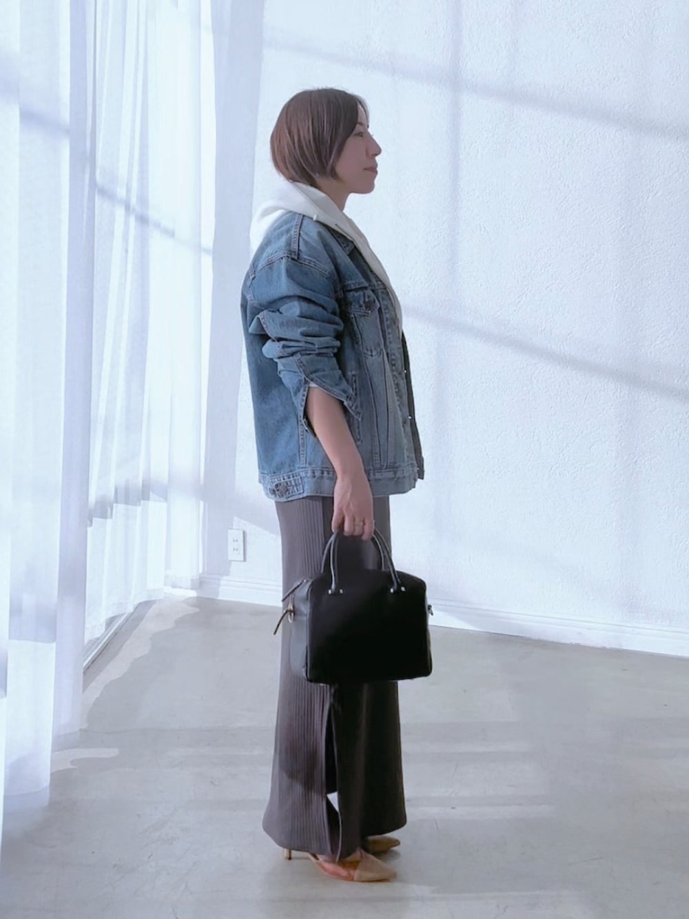 ブルー系のデニムジャケット、グレー系のワンピース、ブラウン系のパンプスを着用したレディースの冬コーディネートの4枚目の写真