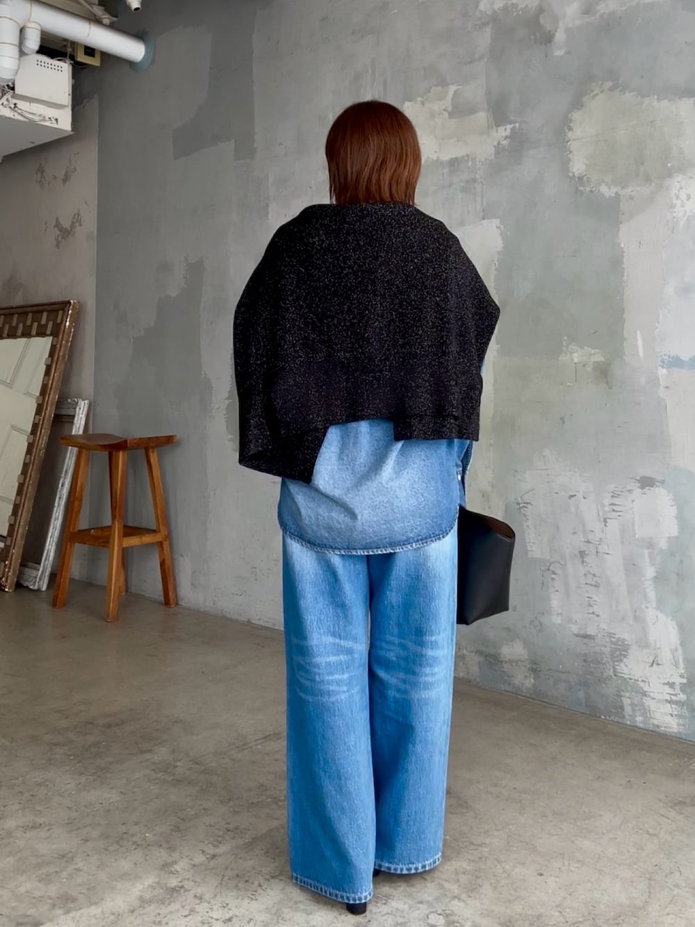 ブラック系のハンドバッグ、ブルー系のデニムパンツ、ブルー系のシャツ/ブラウスを着用したレディースの秋コーディネートの4枚目の写真